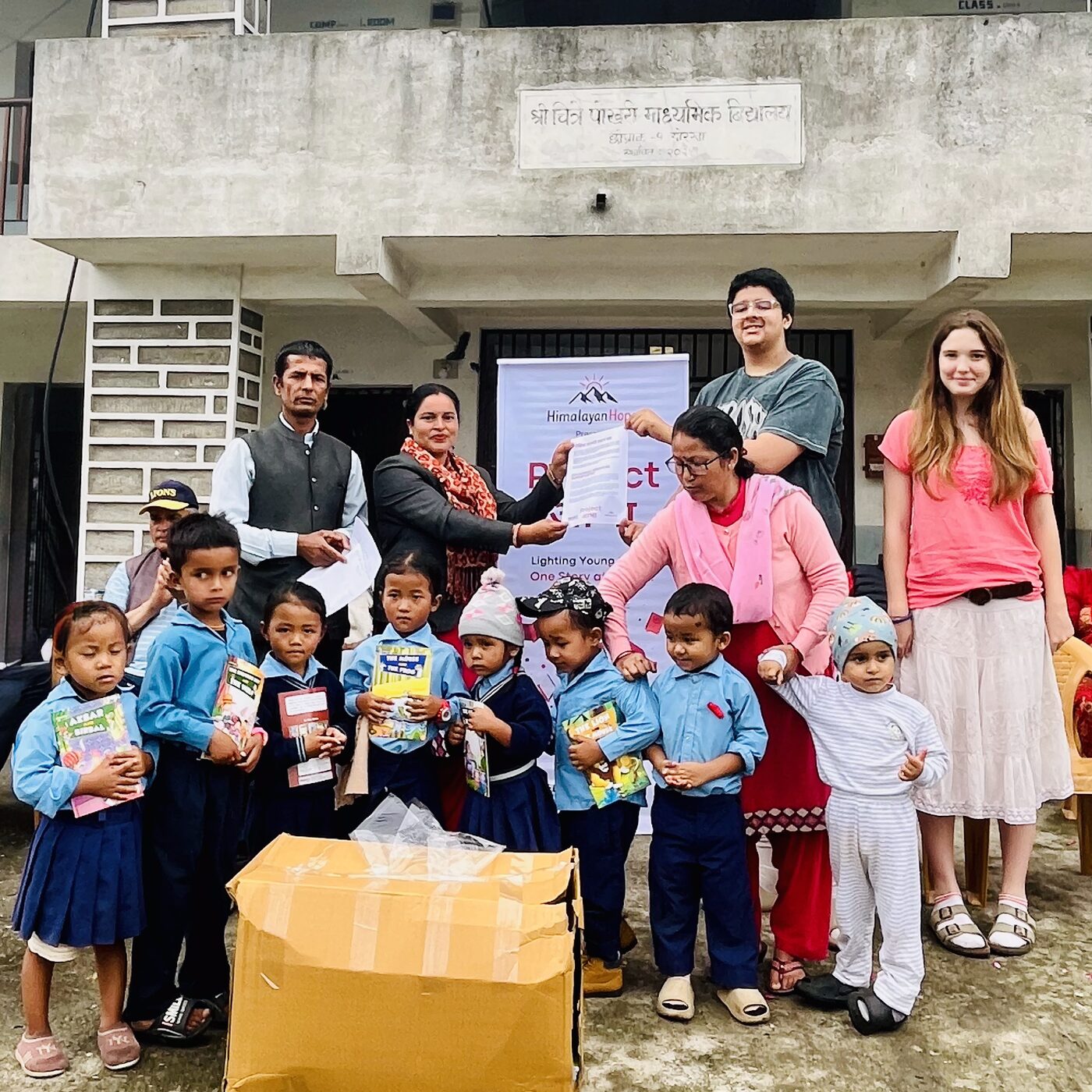 Books being handed to young learners at a Project Aabha event